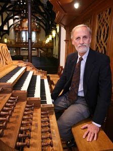 Fred Burgomaster sitting on a pipe organ bench